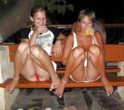 Mother And Daughter Drink Alcohol With Legs On The Bench