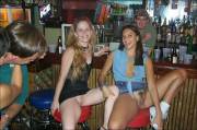 A Couple Girls Sitting Spread Eagle On Bar Stools.